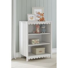 a white book shelf with stuffed animals on top