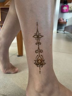 a woman's foot with a tattoo design on the side of her leg,