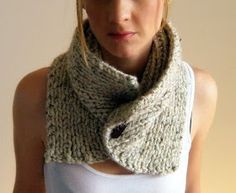 a woman wearing a white tank top and a knitted cowl scarf around her neck