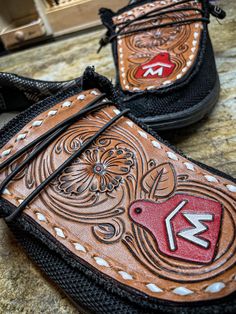 two brown and black shoes with designs on them