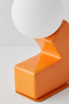 an orange object with a white sphere on top