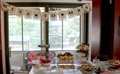 an assortment of desserts and pastries on a table in front of a window