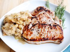 a white plate topped with meat and potatoes