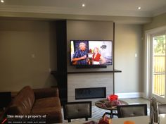 a flat screen tv mounted above a fireplace in a living room