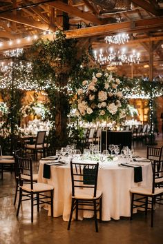 the tables are set with white and black linens for an elegant wedding reception at the barn