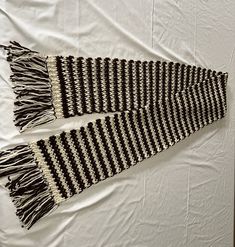 two black and white scarfs laying on top of a bed