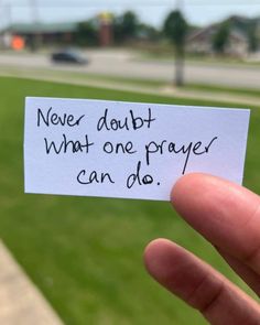 someone holding up a piece of paper that says never doubt what one prayer can do