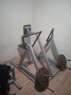 a gym equipment set up on the floor in front of a white wall and wooden floors