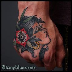 a woman's hand with a flower tattoo on it