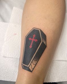 a tattoo on the leg of a person with a black and red cross on it