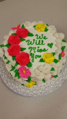 a white cake with flowers and the words we will miss you on it's frosting