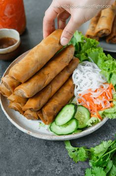 some food is on a plate with lettuce, carrots and cucumbers