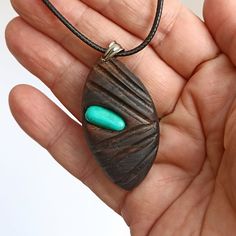 Embrace the serene beauty of nature and the calming influence of healing stones with this exquisite  Ebony Necklace with Green Howlite stone.  This unique piece showcases the rustic charm of a leaf-shaped grain pattern, thoughtfully inlaid with the vibrant tranquility of green howlite mineral. Not only is howlite known for its soothing properties that calm an overactive mind and promote restful sleep, but it is also revered for connecting its wearer to a higher spiritual consciousness, encouragi Bohemian Teardrop Large Stone Necklace, Bohemian Raw Stone Pendant Jewelry, Nature-inspired Teardrop Necklace For Healing, Natural Spiritual Jewelry As A Gift, Spiritual Natural Color Necklaces As Gift, Handmade Natural Spiritual Jewelry, Handmade Spiritual Natural Jewelry, Nature-inspired Raw Stone Pendant Jewelry, Nature-inspired Raw Stone Healing Jewelry