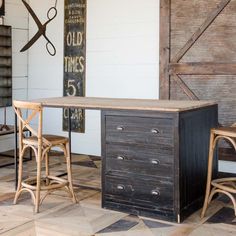 two wooden chairs sitting next to an old fashioned desk and chair in a room with wood floors