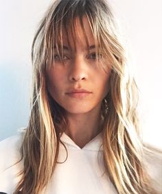 a woman with long blonde hair wearing a white shirt