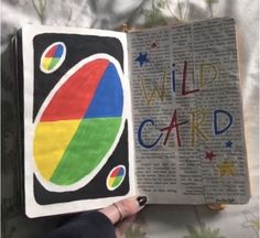 an open book with the words wild card written in rainbow colors and stars on it