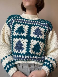 a woman wearing a crocheted sweater with an interesting design on the front and back