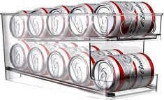 several cans of soda are stacked on top of each other in a display case with clear shelves