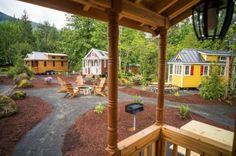 small cottages are located in the woods near a path and picnic table with chairs on it