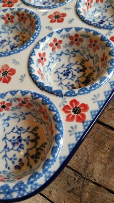 four blue and red dishes sitting on top of a wooden table