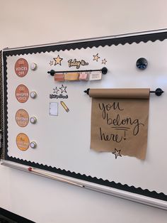 a bulletin board with writing on it and magnets attached to the back of it