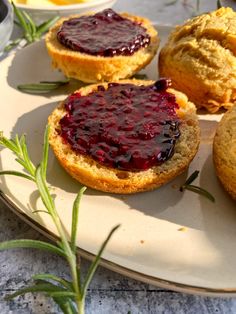 three biscuits with jam on them sitting on a plate