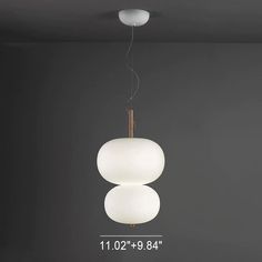 a white light hanging from the ceiling in a room with dark walls and flooring