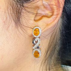 ENJOY OUR WORRY-FREE SERVICE AND THE DAZZLING, GENUINE JEWELRY WE DESIGN AND HANDCRAFT WITH LOVE❤️ ABOUT THE ITEM: SPARKLING! SHIMMERING, DANGLING VIVID ORANGE YELLOW SAPPHIRE EARRINGS! SO PRECIOUS! CERTIFIED 12.68 Total Carats, with 4 pieces of Thai yellow sapphires and 1.21 carats of F/VS, natural diamonds, set in handmade 10.0 grams, 18K solid white gold, CHIC dangling earrings. One of a kind! At 3.6 centimeter in drop length, perfect for both formal and causal events! ONE OF A KIND HANDCRAFT Exquisite Oval Diamond Earrings For Anniversary, Luxury Oval Diamond Earrings For Gift, Dazzling Oval Earrings For Anniversary, Exquisite Oval Diamond Cut Earrings, Yellow Halo Design Earrings For Gift, Orange Earrings For Anniversary In Fine Jewelry Style, Gift Yellow Round Diamond Earrings, Oval Cubic Zirconia Earrings Hallmarked, Yellow Oval Gemstone Earrings