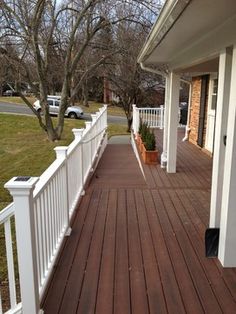 a porch with wooden floors and white railings