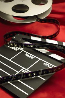 a movie clapper and reel on a red cloth