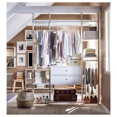 an organized closet with clothes, shoes and suitcases hanging on the wall next to it