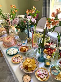 a table full of food and flowers on it's side, including donuts