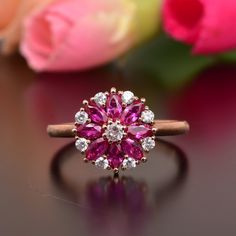 a pink diamond ring sitting on top of a table