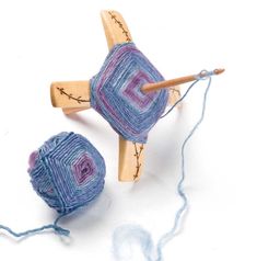 two yarn balls are next to a knitting needle