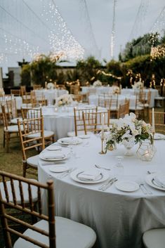 the tables are set with white linens and place settings for an elegant wedding reception