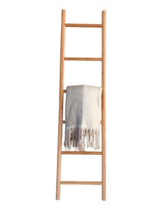 a wooden ladder with a white towel on it and a gray blanket hanging from the top