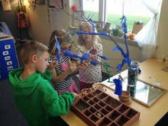 two children and an adult working on crafts