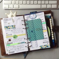 an open notebook sitting on top of a desk next to a keyboard