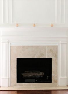 an empty fireplace with white paint on the mantle