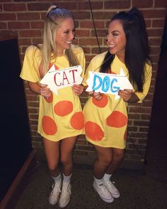 two women in costumes holding signs that say cat and dog