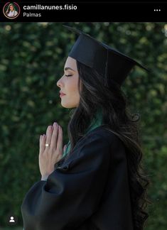 a woman wearing a graduation gown and holding her hands together