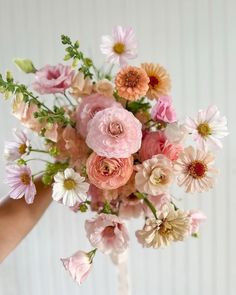 a person holding a bouquet of flowers in their hand