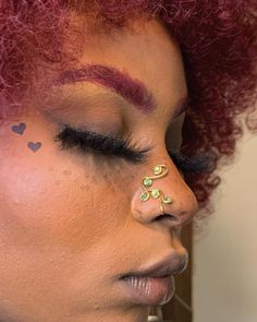 a woman with red hair and piercings on her nose