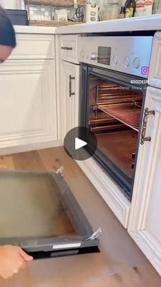 a man is opening an oven in the kitchen