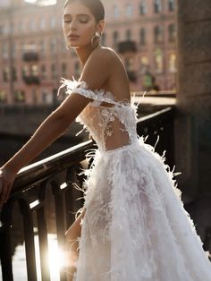 a woman in a white dress leaning on a railing