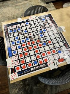 a board game sitting on top of a wooden table next to two black and white chairs