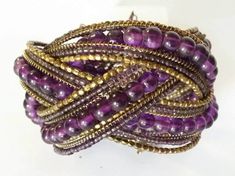 Vintage On Esty Boho Genuine Amethyst Gemstone Beaded Brass Memory Wire Wide Cuff Multi Strand Woven Bracelet Bracelet is Woven brass wire stretch with 21 strands! Large Round Genuine Amethyst Beads. Amethyst and Brass seed Beads!  MEASUREMENTS 9 inches Length 2.5 inches Width Perfect Condition! Sorry No returns or returns Insurance OR Special shipping  CAN BE ACCOMMODATED   Ask before order :) Purple Jewelry With Gold Beads For Party, Purple Gold Beaded Party Jewelry, Adjustable Purple Bohemian Cuff Bracelet, Purple Beaded Bangle Jewelry, Purple Wire Wrapped Beaded Bracelets, Bohemian Amethyst Beaded Bracelets, Handmade Bohemian Purple Bangle, Bohemian Purple Bracelets For Party, Bohemian Purple Bracelet For Party