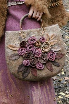 a woman holding a purse with flowers on it