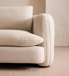 a white couch sitting on top of a hard wood floor