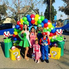 a group of people standing next to each other in front of a bunch of balloons